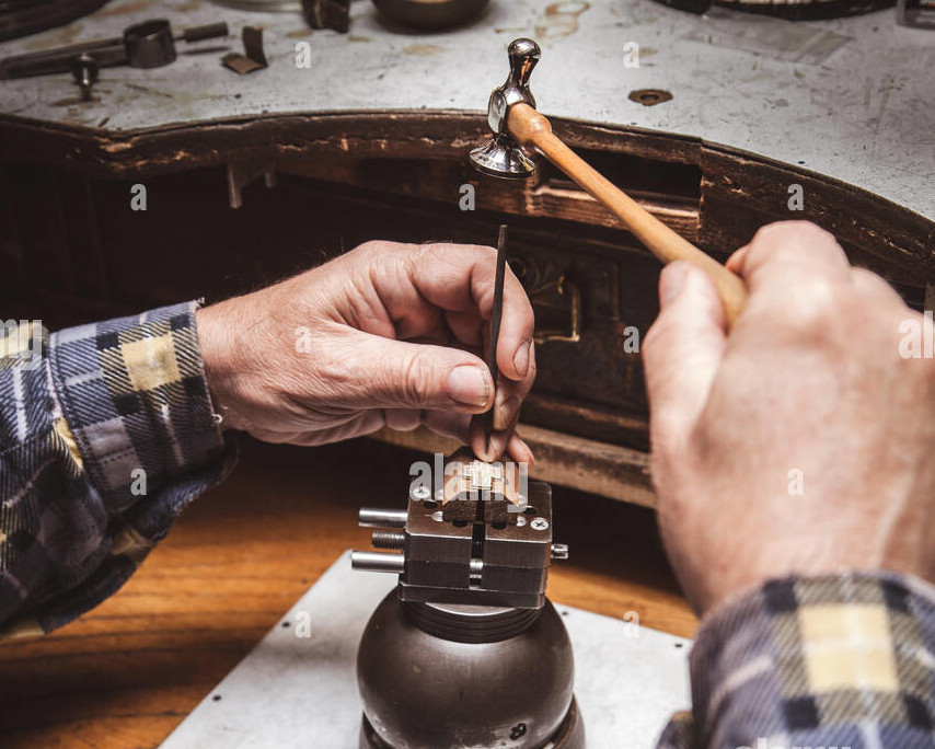 The artist's hands working on a jewelry piece.